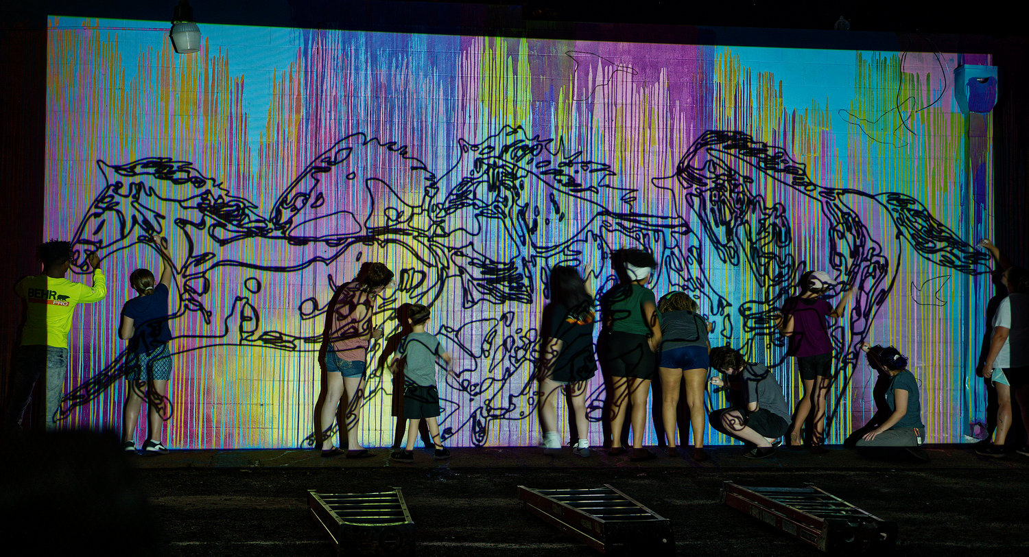 Participants trace the outline for the mural as projected onto the wall.